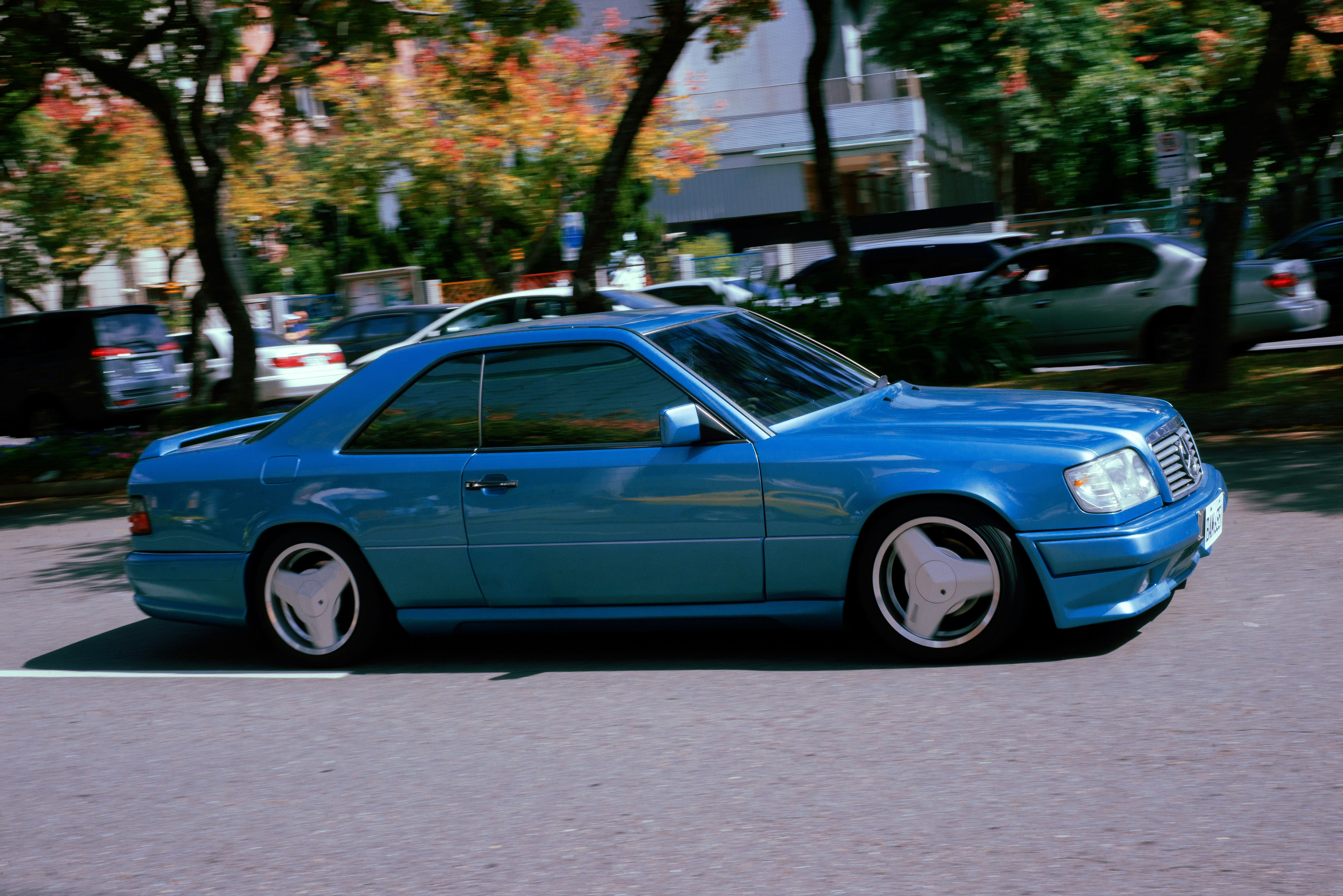 blue sedan on gray asphalt road during daytime